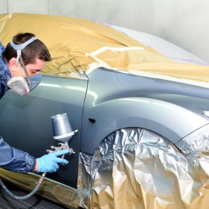 Worker painting a car.